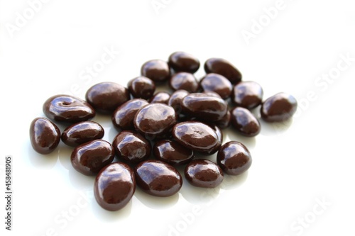 Dark chocolate covered nuts on white background
