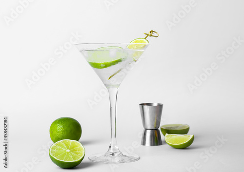 Glass of tasty gin and tonic on light background