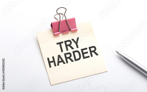 TRY HARDER text on the sticker with pen on the white background