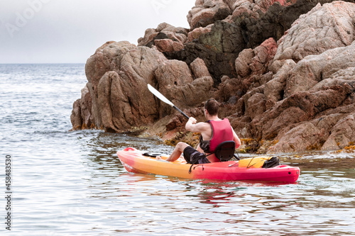 Foto man kayaking on the catalan costa brava in front of a rock