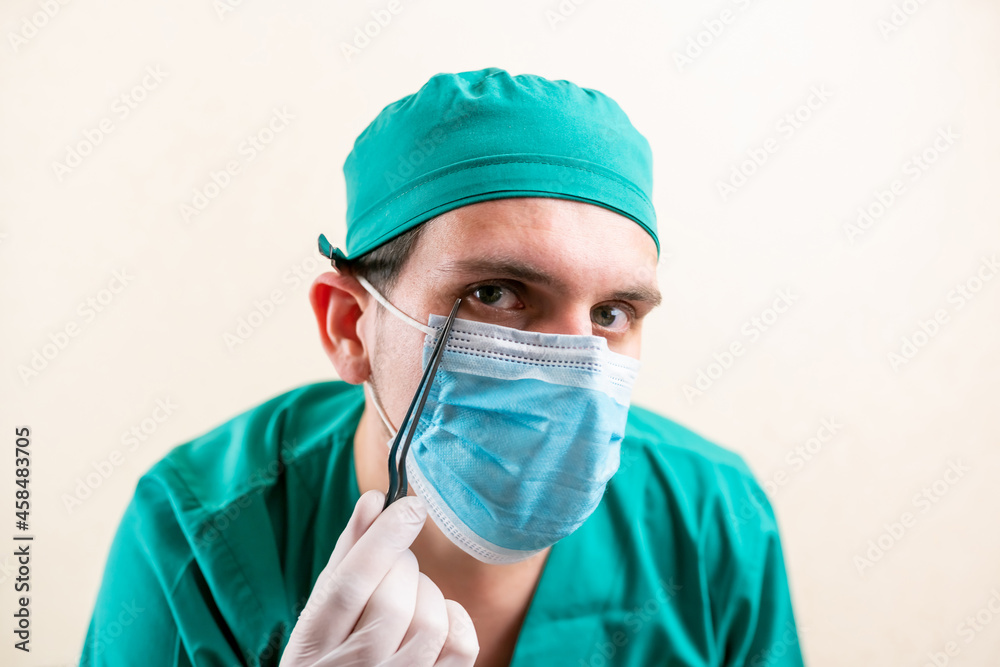 Doctor ENT, wearing a mask and glasses, with a device in his hands. Doctor ENT, wearing a mask and glasses, with a device in his hands.