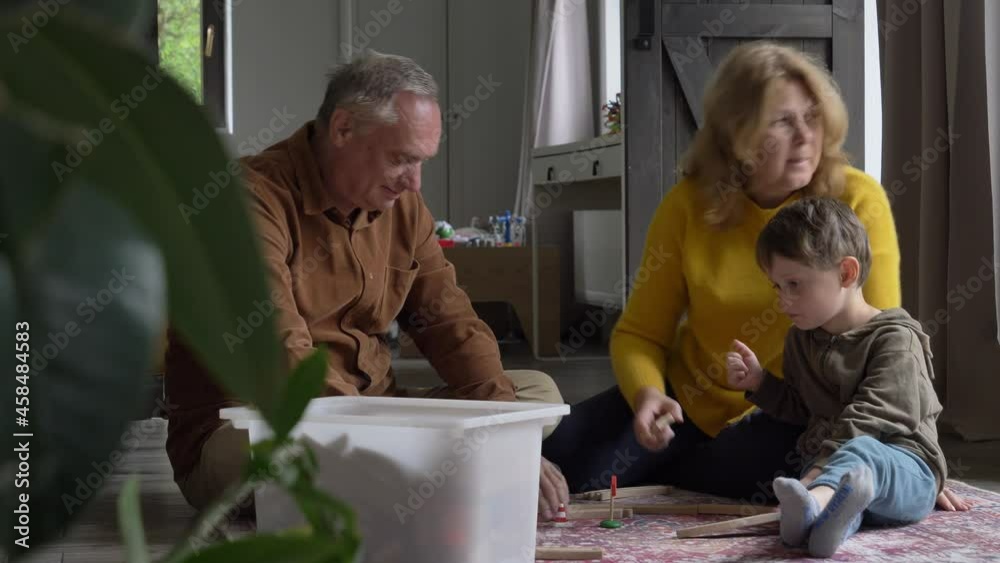 grandparents play the railway with their grandson at home. Video 4K grandparents play the railway with their grandson at home. Video 4K