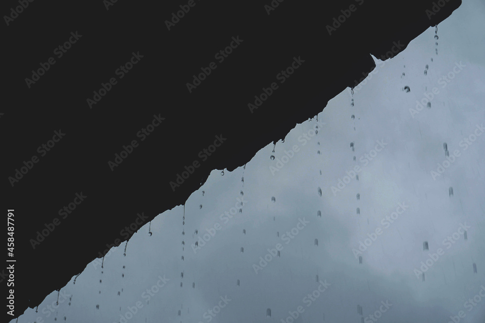 Rain drop falling from old roof tiles Rain drop falling from old roof tiles