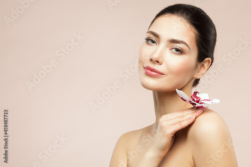Wallpaper Mural Beautiful Model Girl holding Orchid Flower on Shoulder. Beauty Woman with Perfect Healthy Skin and Natural Makeup. Body and Face Care Cosmetics Torontodigital.ca
