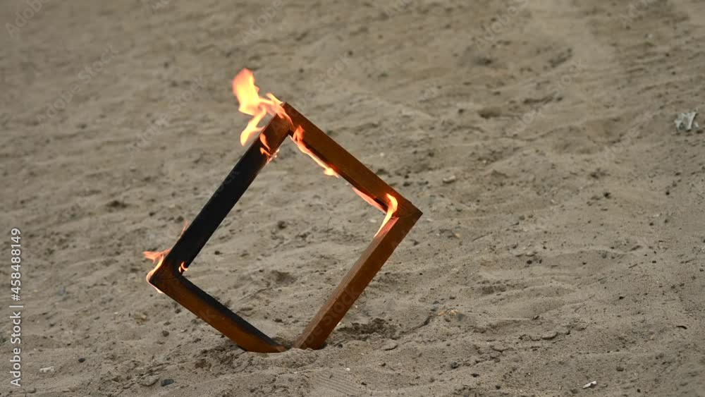 Wooden photo frame on fire on the beach. Wooden photo frame on fire on the beach.