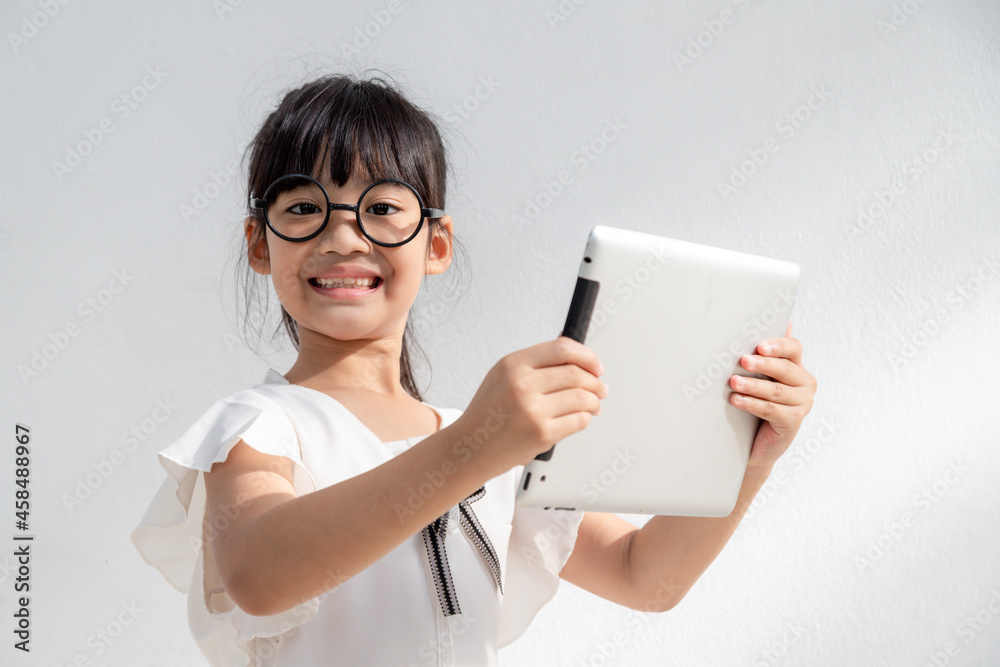 Shocked and surprised little girl on the internet with digital tablet computer concept for amazement, astonishment, making a mistake, stunned and speechless or seeing something he should not see Shocked and surprised little girl on the internet with digital tablet computer concept for amazement, astonishment, making a mistake, stunned and speechless or seeing something he should not see