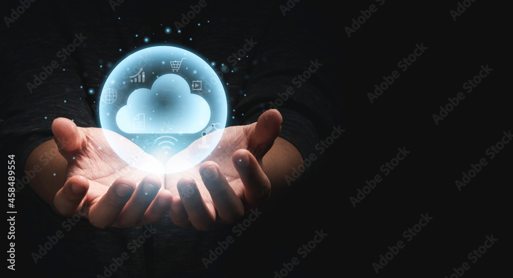 © Dilok - Two hands holding virtual could computing with technology icons with dark background and copy space for technology transformation and sharing concept.