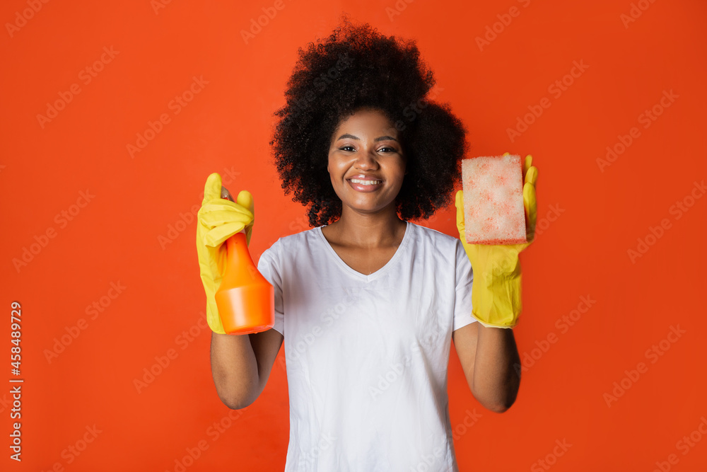 cute african woman with afro hairstyle with spray and sponge in her hands cute african woman with afro hairstyle with spray and sponge in her hands
