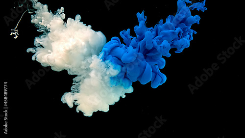White-blue cloud of ink. Cosmic magic background. Blue and white watercolor ink in water on a black background. Waves and drops of blue and white paints.
