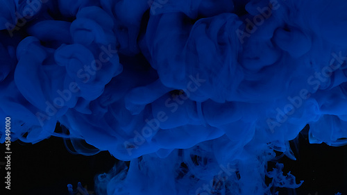 Blue cloud of ink. Cosmic magic background. Waves and drops of blue paint. Beautiful abstract background.