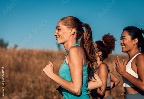 Group of female friends running outdoors.