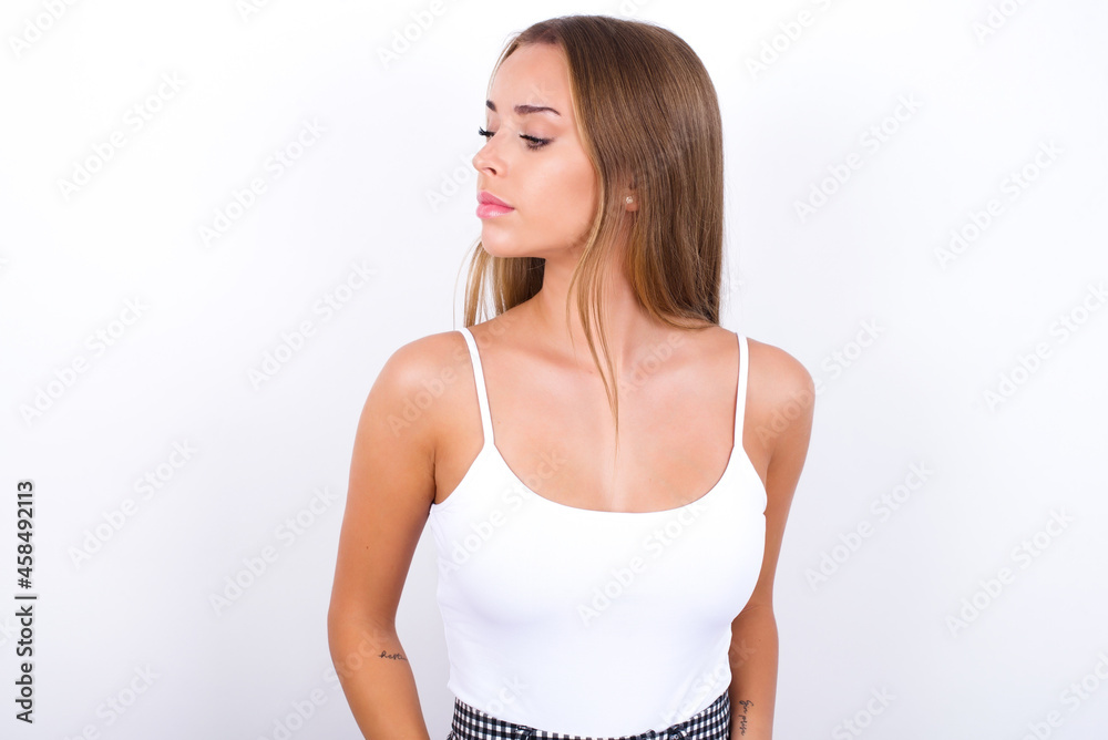 Side view of young happy smiling beautiful blonde girl wearing sexy t-shirt on white background Side view of young happy smiling beautiful blonde girl wearing sexy t-shirt on white background