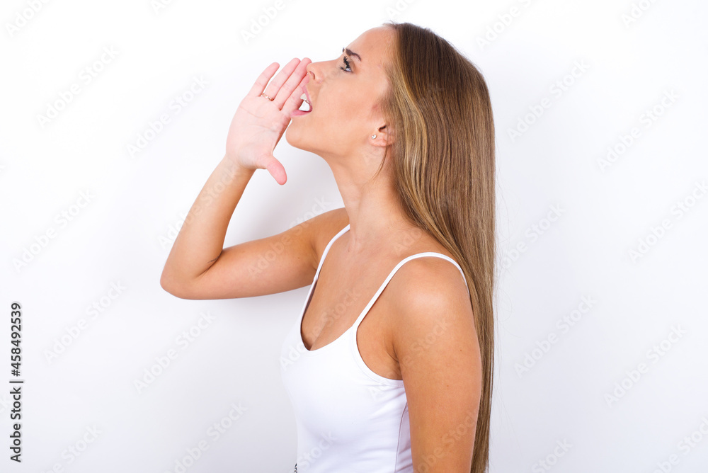 beautiful blonde girl wearing sexy t-shirt on white background profile view, looking happy and excited, shouting and calling to copy space. beautiful blonde girl wearing sexy t-shirt on white background profile view, looking happy and excited, shouting and calling to copy space.