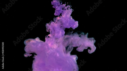 Amazing space magic background. Purple watercolor ink in water on a black background. Purple ink cloud. Waves and drops of violet paints.