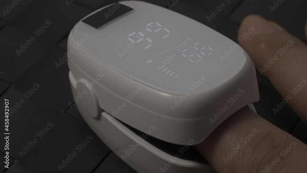 Oximeter usage. Finger pulse oximeter used to measure pulse rate and oxygen levels. Home self care during Covid 19 pandemic. healthcare monitoring concept. using portable fingertip pulse oximeter. 4k Oximeter usage. Finger pulse oximeter used to measure pulse rate and oxygen levels. Home self care during Covid 19 pandemic. healthcare monitoring concept. using portable fingertip pulse oximeter. 4k
