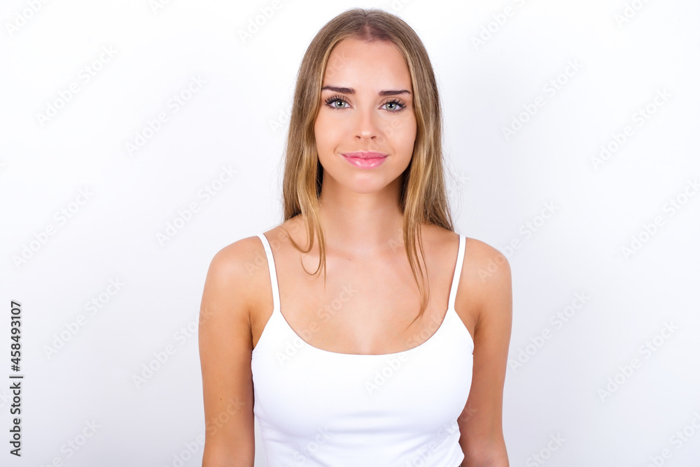 Happy beautiful blonde girl wearing sexy t-shirt on white background looking at camera with charming cute smile. Happy beautiful blonde girl wearing sexy t-shirt on white background looking at camera with charming cute smile.