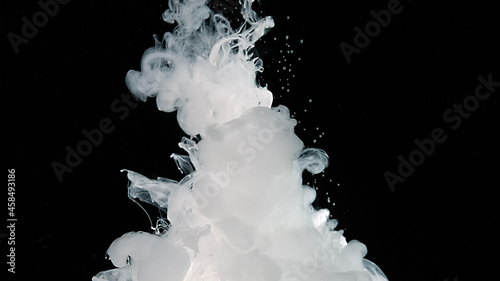 Abstract background. Waves of milky ink and splashes of white paints in the water. White cloud of ink on a black background.
