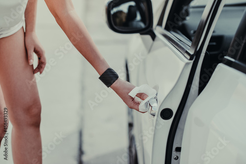 woman hand cleaning on car door handle, outside car against Novel coronavirus or Corona Virus Disease (Covid-19). Antiseptic, Hygiene and Healthcare concept