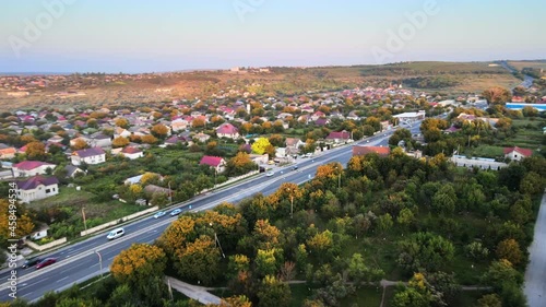 Aerial drone view of Tipova, Moldova at sunset. Road with cars, residential buildings, greenery photo