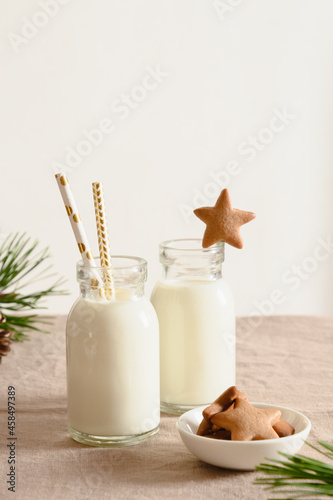 Homemade Christmas cookies and milk for Santa on table with tablecloth. Close up. Xmas holiday traditional treats.