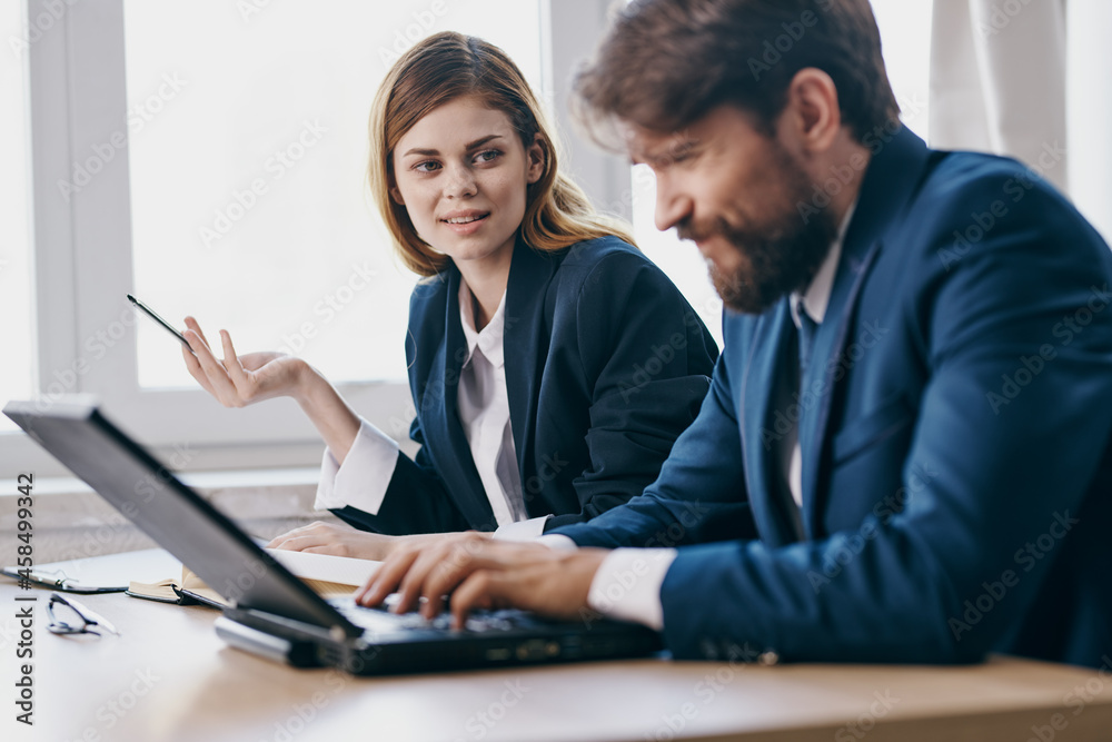 Obraz premium colleagues sitting at a desk with a laptop communication professionals
