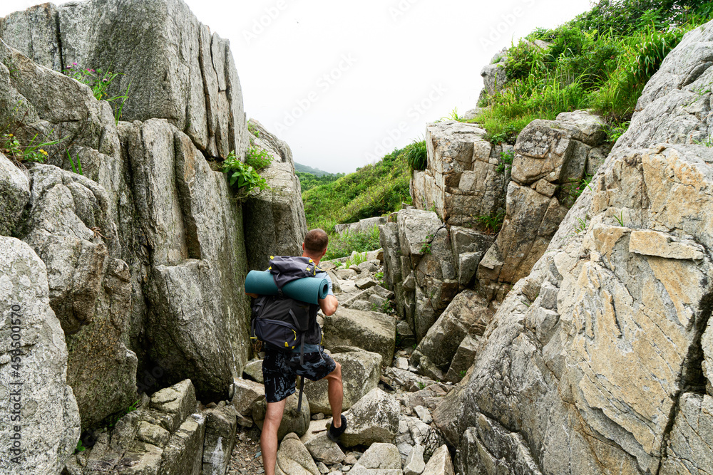 Back view hiker man with backpack going at hilly terrain natural mountain enjoy adventure