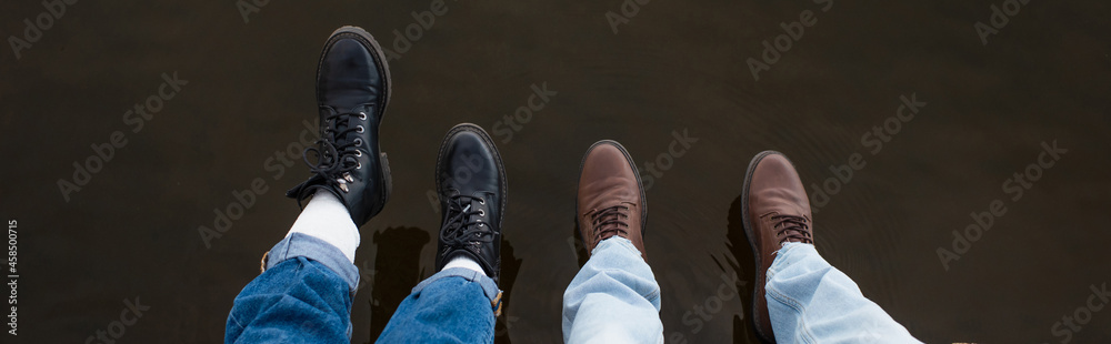 Top view of legs of couple above lake water outdoors, banner Top view of legs of couple above lake water outdoors, banner