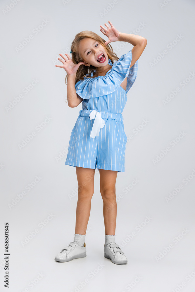 Full-length portrait of smiling girl in casual clothes having fun isolated on white studio background. Happy childhood concept. Sunny child. Looks happy, delighted Full-length portrait of smiling girl in casual clothes having fun isolated on white studio background. Happy childhood concept. Sunny child. Looks happy, delighted