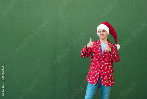 Man gesturing to be okay while dressing christmas costume in a green background