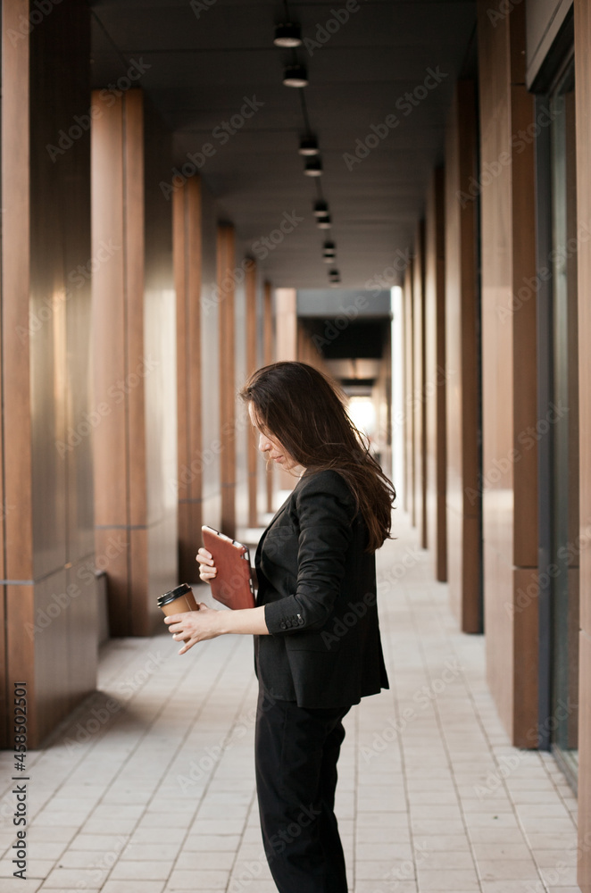 Young millennial businesswoman working near office building holding tablet Young millennial businesswoman working near office building holding tablet