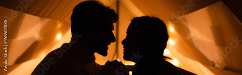 Side view of silhouettes of couple in glamping house, banner
