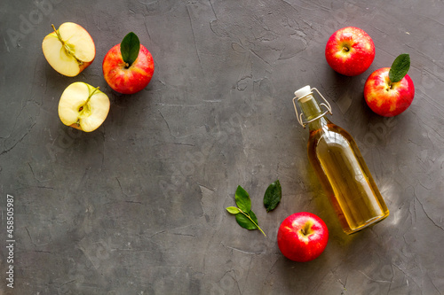 Foto Bottle of organic apple cider vinegar with red apples