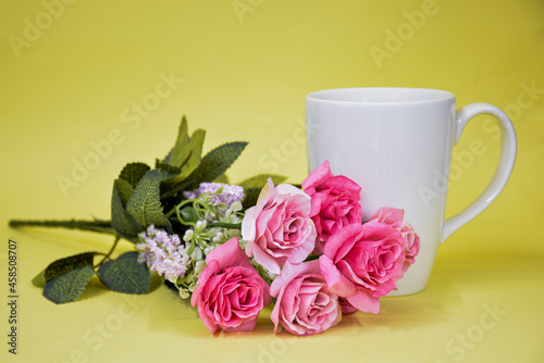 White cup of tea with pink roses