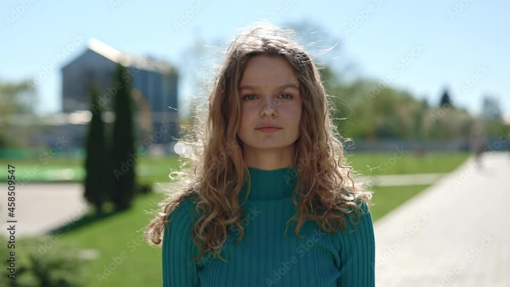 Woman with blond curly hair and blue eyes posing outdoors Woman with blond curly hair and blue eyes posing outdoors