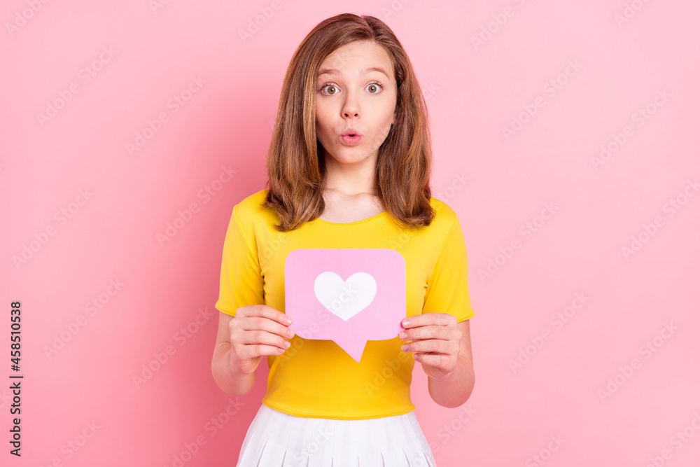 Photo of young girl amazed shock surprised hold like heart reaction icon blogger isolated over pink color background Photo of young girl amazed shock surprised hold like heart reaction icon blogger isolated over pink color background