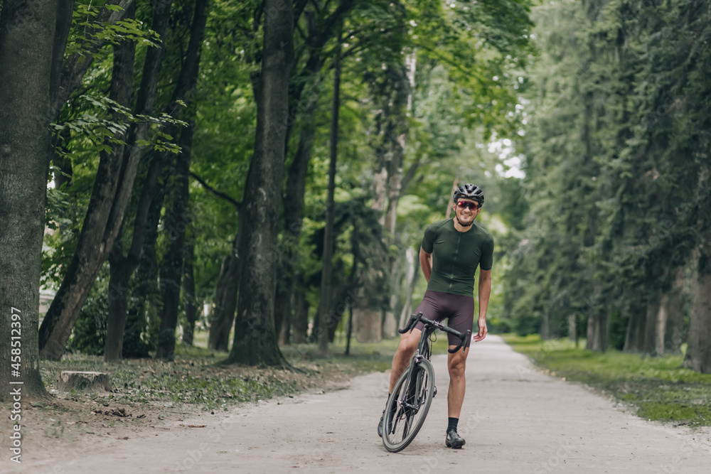 Positive man in activewear taking break after cycling