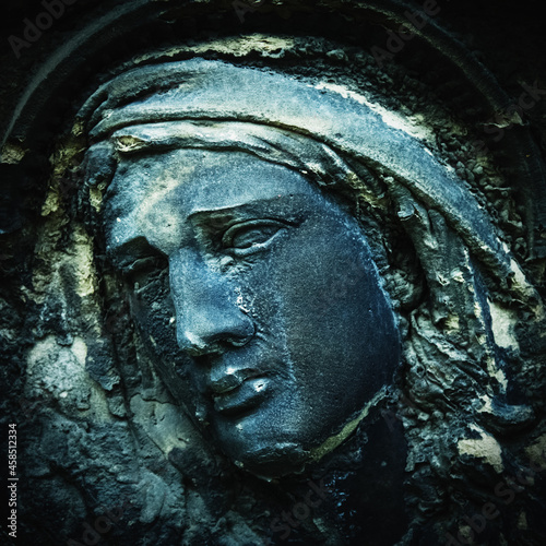 Virgin Mary statue. Fragment of vintage sculpture of sad woman in grief. Religion, faith, suffering, love concept. © zwiebackesser