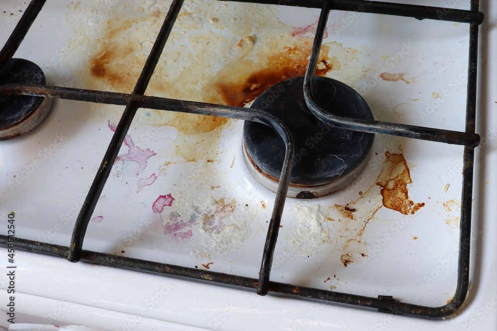 Dirty gas stove with food debris and grease stains. A dirty gas stove