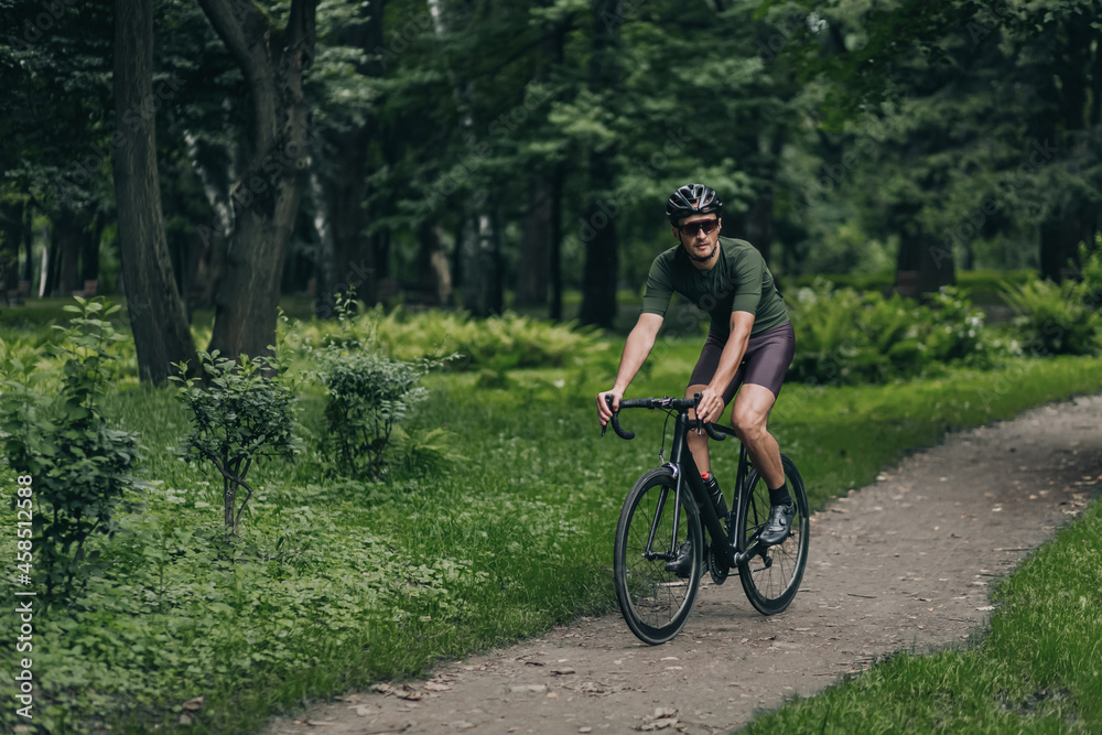 Cyclist in helmet and glasses riding bike outdoors Cyclist in helmet and glasses riding bike outdoors
