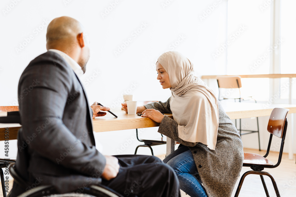 Mid aged african man in wheelchair having lunch break Mid aged african man in wheelchair having lunch break