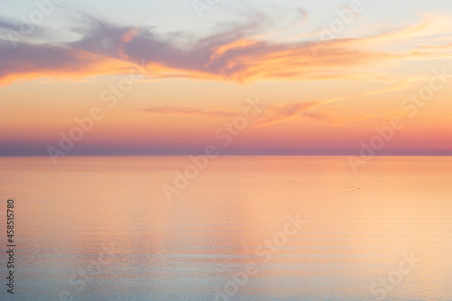 Whispy clouds at sunset over a calm sea