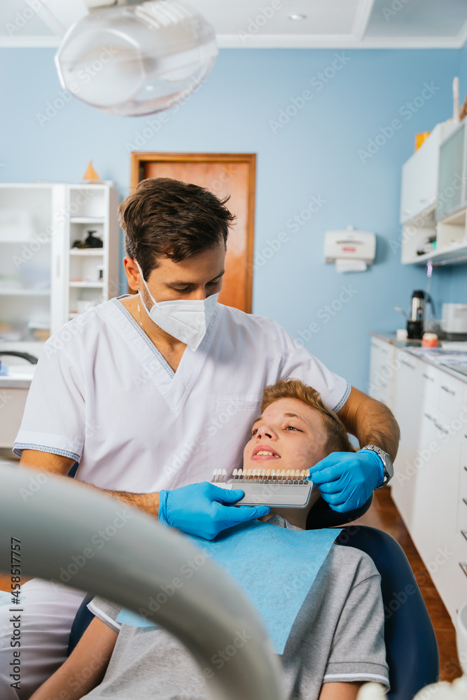 Dentist shows implants to young male patient . Dentist shows implants to young male patient .