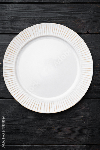 Empty white plate porcelain with copy space for text or food with copy space for text or food, top view flat lay  , on black wooden table background