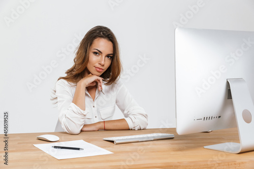 Ginger woman working with computer while sitting at desk