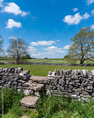 stone wall in the countryside with blue sky and clouds