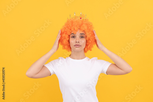 egoistic funny girl with fancy look wearing orange hair wig and princess crown, egoist