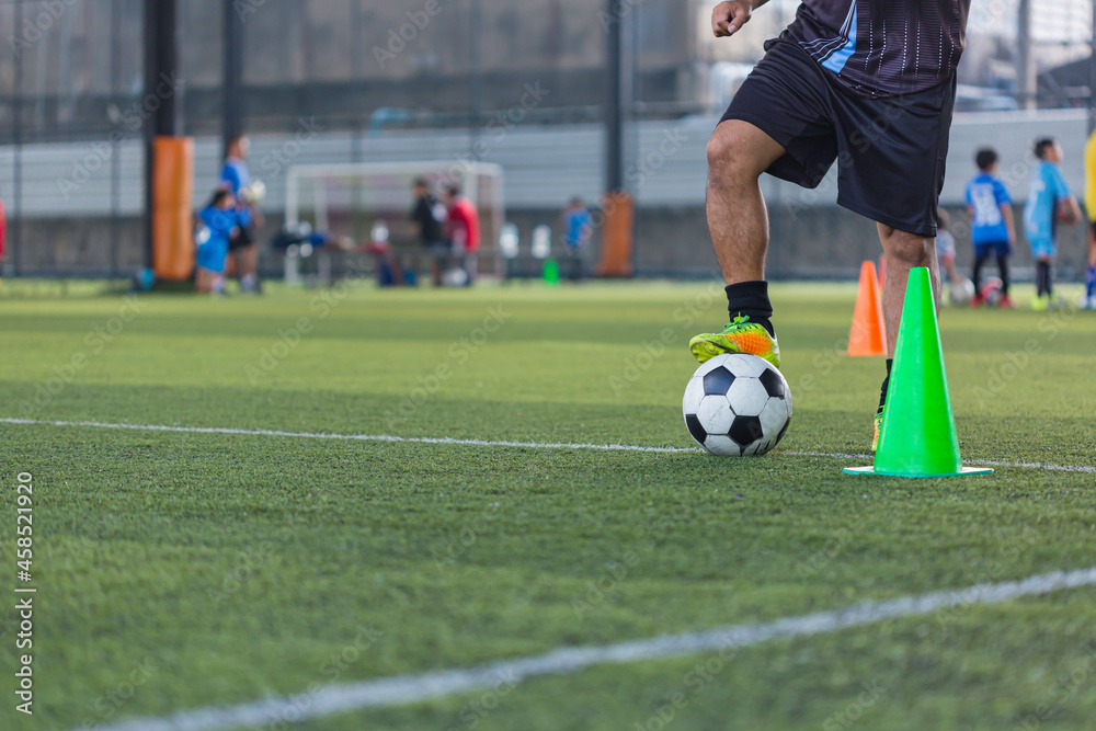 Children playing control soccer ball tactics cone on grass field with for training background Training