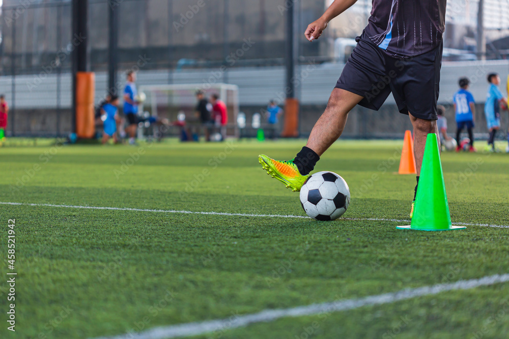 Children playing control soccer ball tactics cone on grass field with for training background Training Children playing control soccer ball tactics cone on grass field with for training background Training