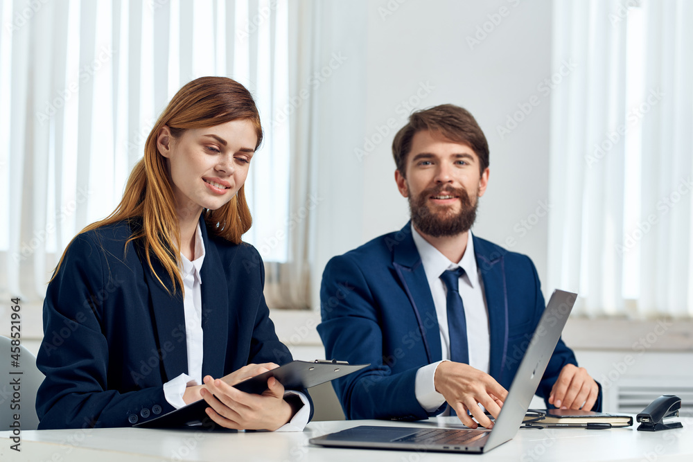 business man and woman talking at the table in front of laptop office technology business man and woman talking at the table in front of laptop office technology