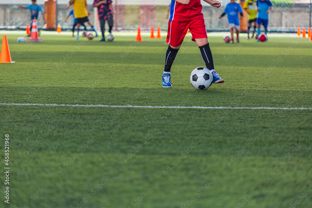 Children playing control soccer ball tactics cone on grass field with for training background Training